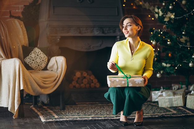 Donna che disimballa i regali dall&#39;albero di Natale