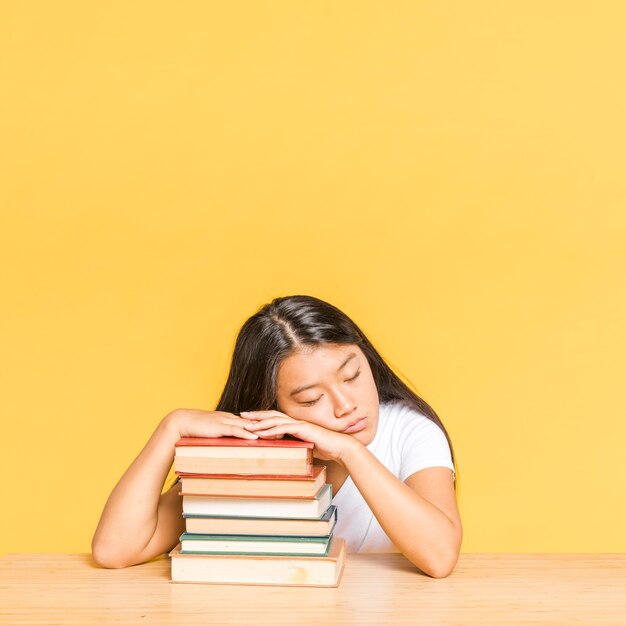 Donna che dorme su una pila di libri