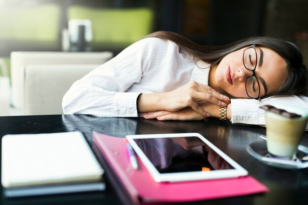 Donna che dorme sul tavolo nella caffetteria