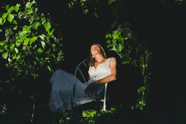 Donna che dorme sulla sedia in giardino