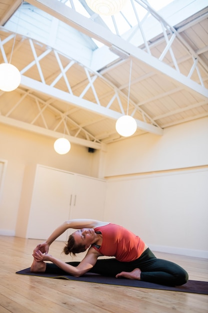 Donna che effettua yoga sulla stuoia di esercitazione