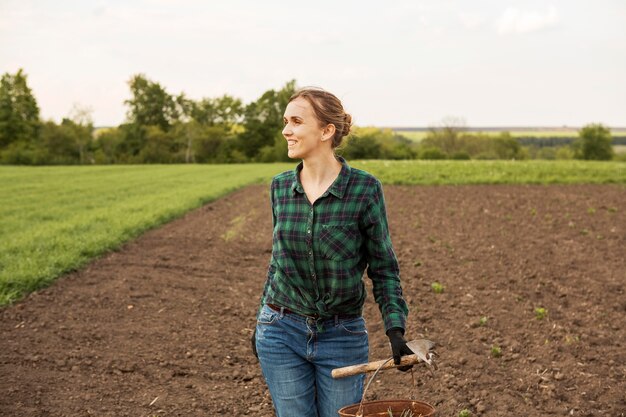 Donna che esamina una terra coltivata