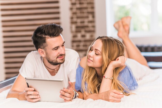 Donna che esamina uomo che tiene compressa digitale sul letto