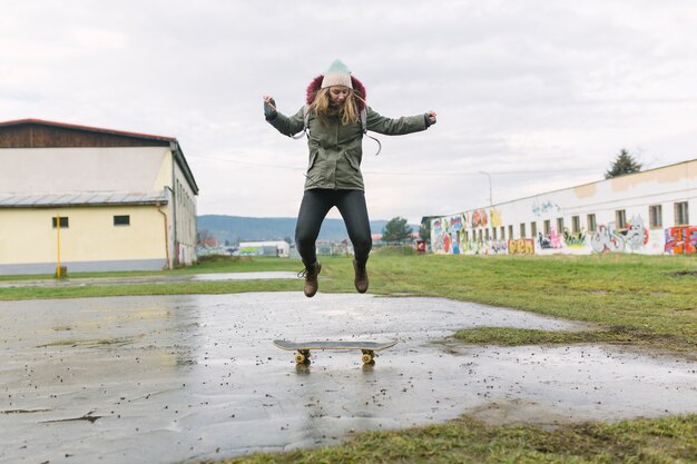 Donna che fa acrobazie su skateboard