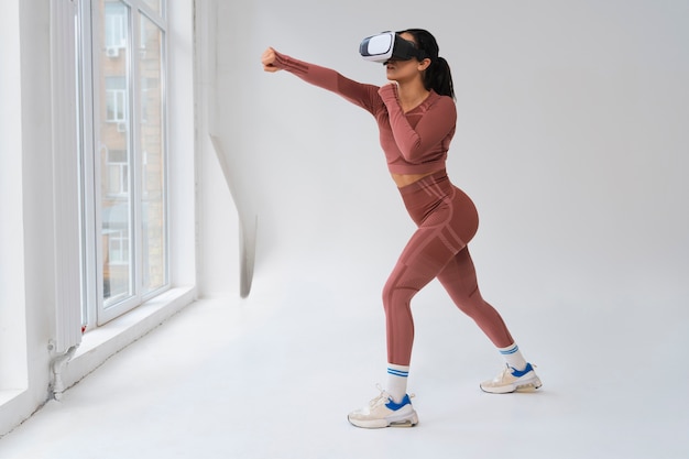 Donna che fa fitness con gli occhiali vr