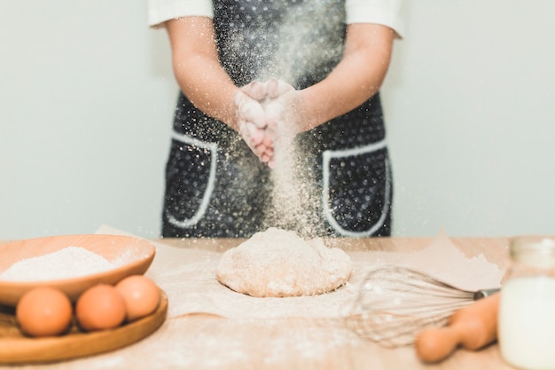 Donna che fa il pane versando la farina