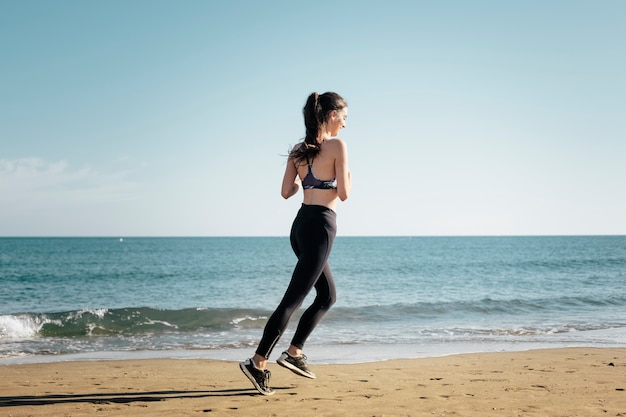 Donna che fa jogging alla spiaggia