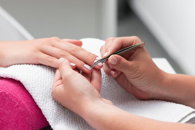 Donna che fa la manicure di un primo piano del cliente