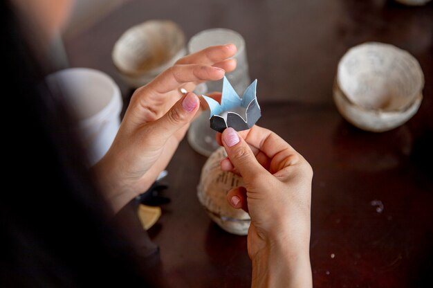Donna che fa origami di fiori da carta