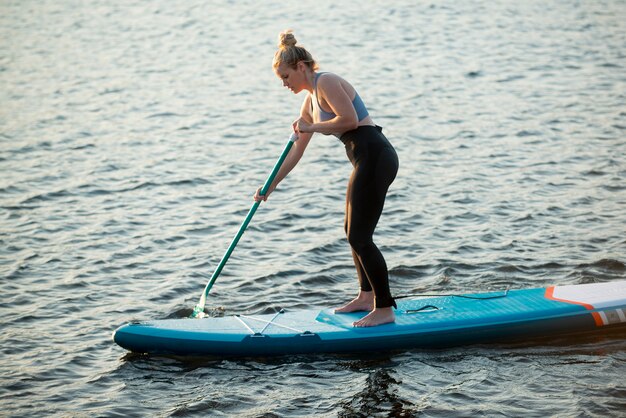 Donna che fa paddleboarding a tutto campo