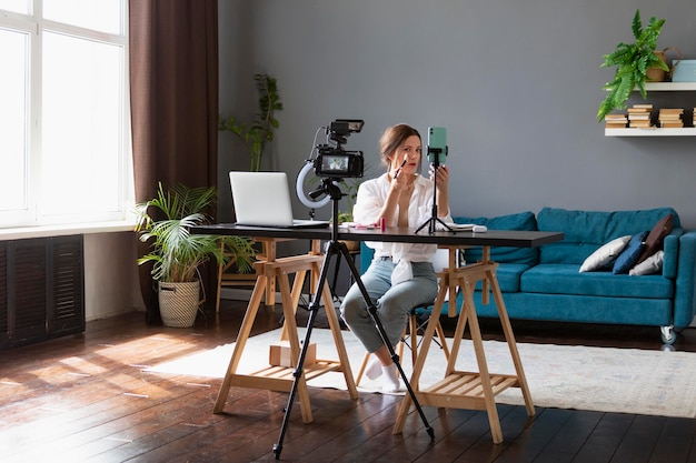 Donna che fa un vlog di bellezza con la sua macchina fotografica professionale