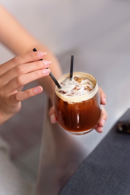 Donna che fa una pausa caffè ghiacciata fuori