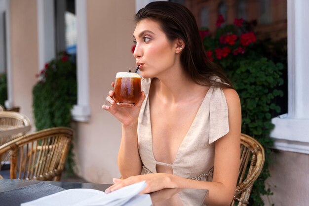 Donna che fa una pausa caffè ghiacciata fuori