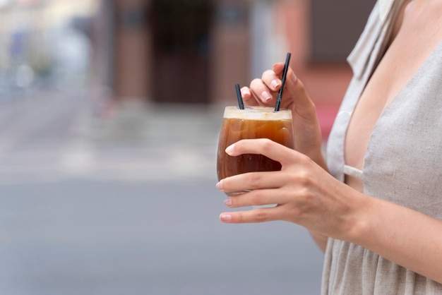 Donna che fa una pausa caffè ghiacciata fuori