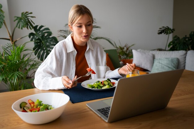 Donna che fa una videochiamata mentre mangia