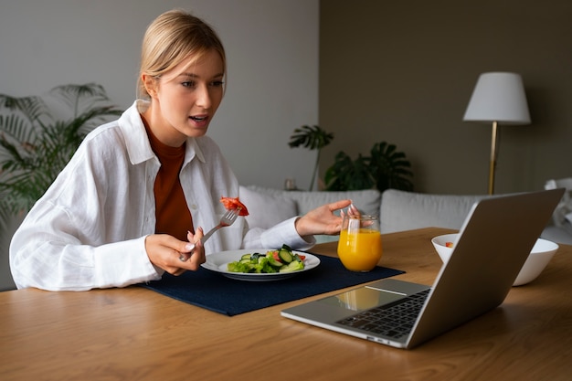 Donna che fa una videochiamata mentre mangia