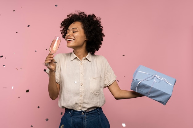 Donna che festeggia con un bicchiere di champagne e un regalo