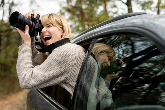 Donna che fotografa dall'automobile commovente