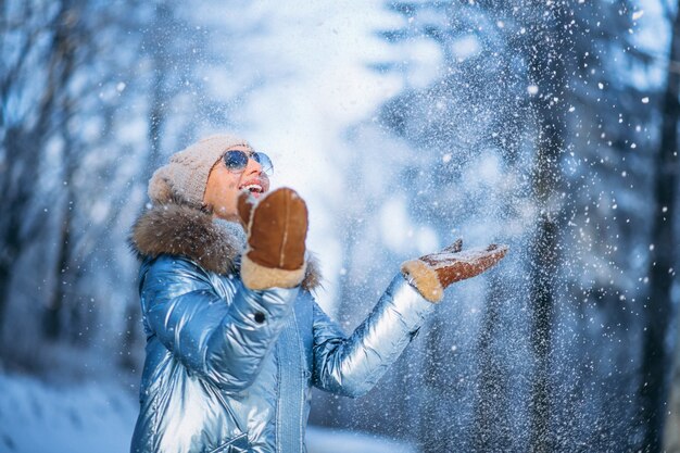 Donna che getta neve nel parco