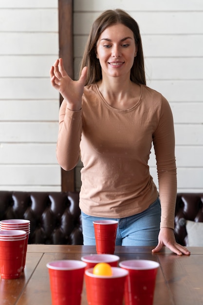 Donna che gioca a beer pong a una festa al coperto