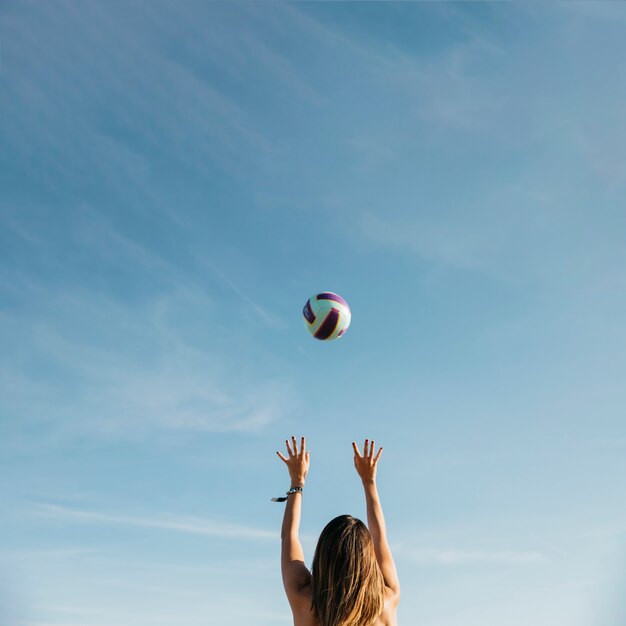 Donna che gioca a pallavolo in spiaggia