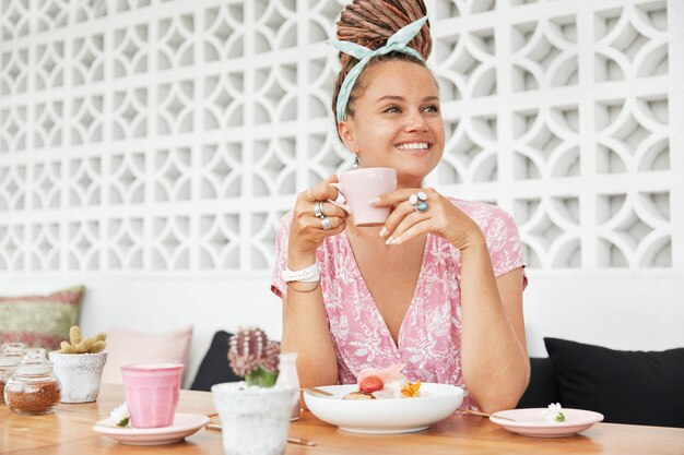 Donna che gode del dessert e della bevanda nella caffetteria