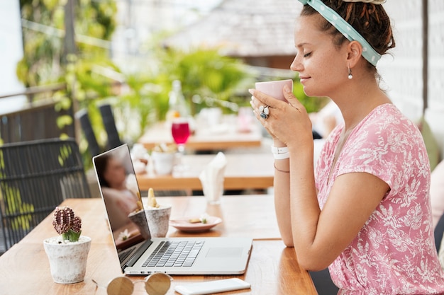 Donna che gode del dessert e della bevanda nella caffetteria