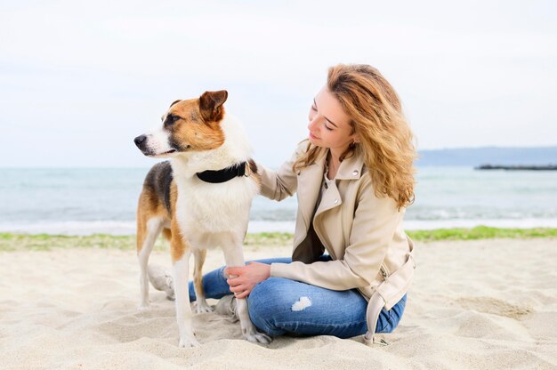 Donna che gode del tempo con il suo cane all'aperto