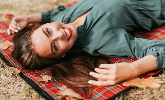 Donna che gode dell'autunno su una coperta da picnic