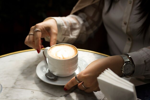 Donna che gode della tazza di cappuccino