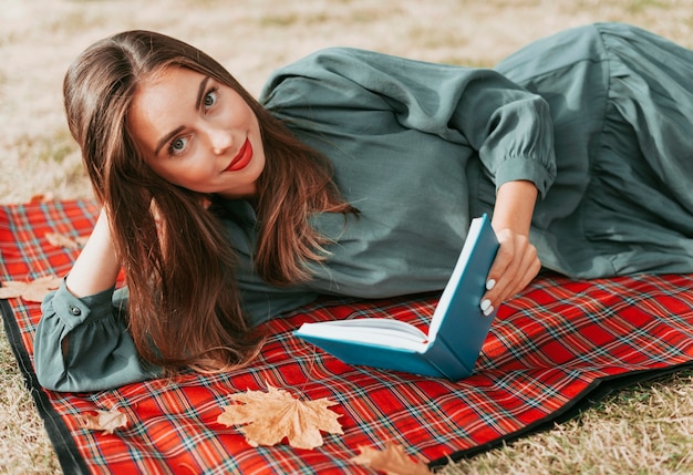 Donna che gode di un libro su una coperta da picnic