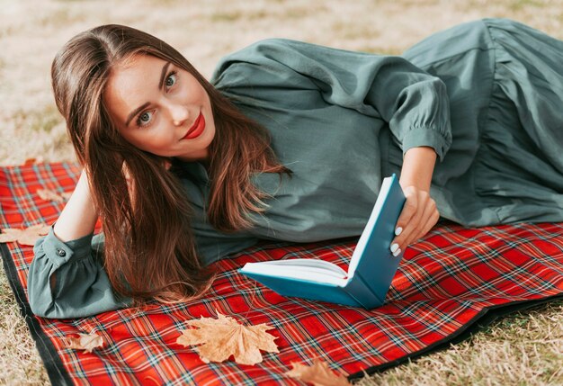 Donna che gode di un libro su una coperta da picnic