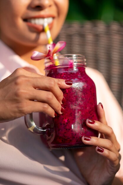 Donna che gode di una bevanda alla frutta del drago all'aperto