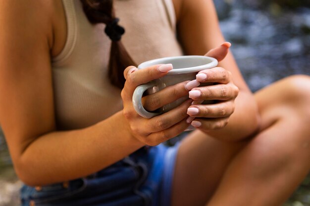 Donna che gode di una tazza di caffè mentre all'aperto