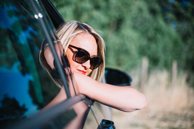 Donna che guarda fuori dalla finestra dell&#39;automobile