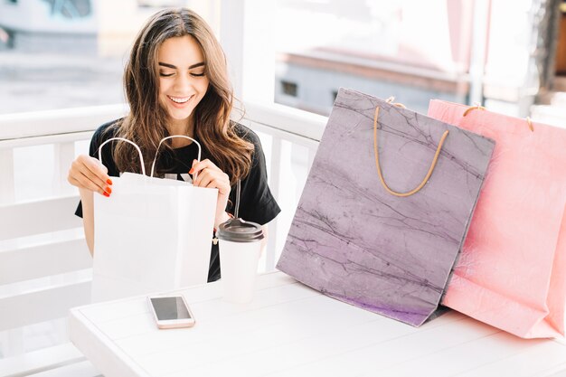 Donna che guarda gli acquisti in sacchetto di carta