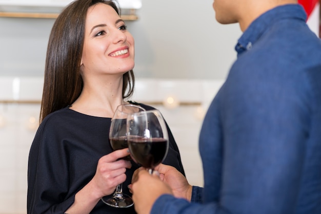 Donna che guarda il marito mentre si tiene un bicchiere di vino