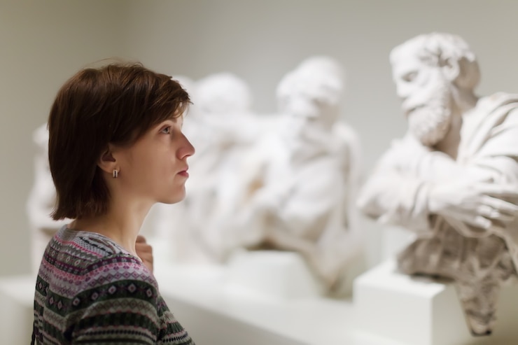 Foto gratuito donna che guarda sculture antiche