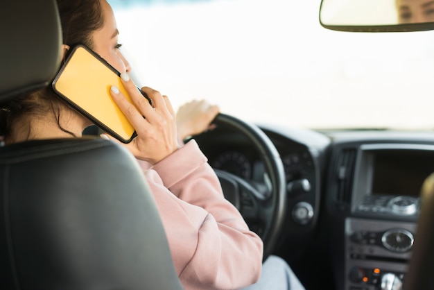 Donna che guida e parla al telefono