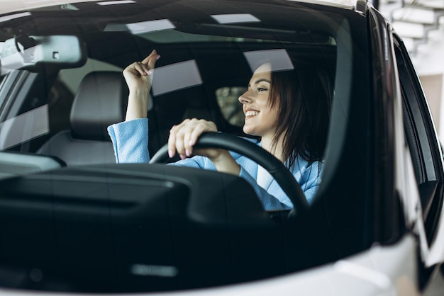 Donna che guida l'auto e balla