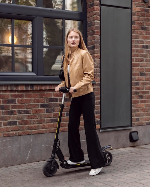 Donna che guida scooter elettrico all'aperto