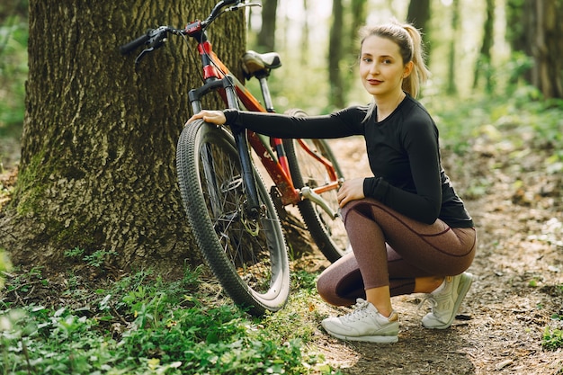 Donna che guida un mountain bike nella foresta