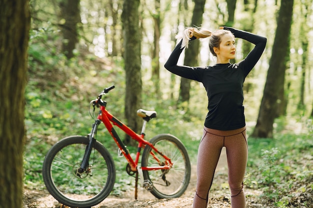 Donna che guida un mountain bike nella foresta