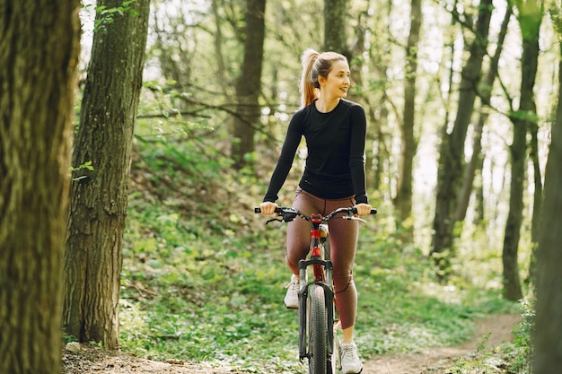 Donna che guida un mountain bike nella foresta