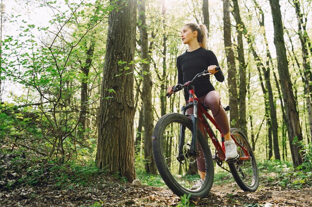 Donna che guida un mountain bike nella foresta