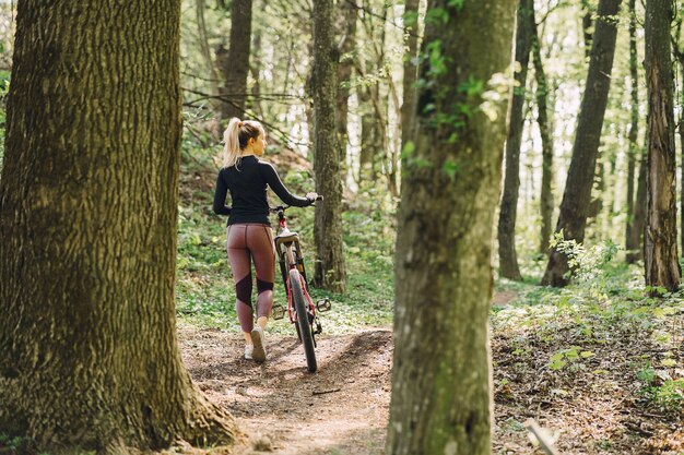 Donna che guida un mountain bike nella foresta