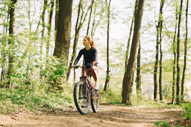 Donna che guida un mountain bike nella foresta