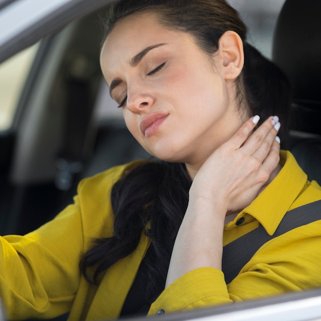 Donna che ha dolore al collo dalla guida