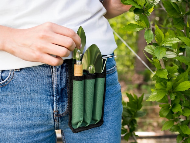 Donna che ha il primo piano degli strumenti di giardinaggio