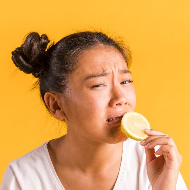 Donna che ha paura di mordere un limone